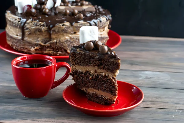 Filiżanka kawy i duże ciasto czekoladowe z polewą czekoladową i che — Zdjęcie stockowe
