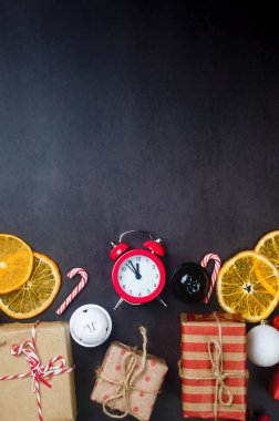 El işi kağıdına sarılı hediyeler Noel ağacı için ahşap oyuncaklar, alarm, koyu arkaplanda kuru portakallar. Yeni yıl ya da kış arifesi kompozisyonu. Noel zamanı konsepti. Tebrik kartı,