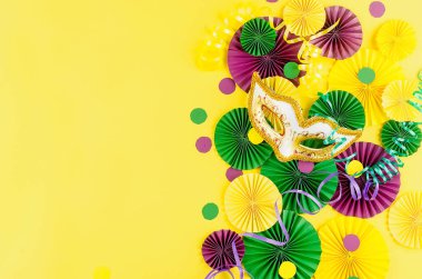 Renkli kağıt konfetileri, karnaval maskesi ve sarı arka planda fotokopi alanı, tebrik kartı ve karnaval ya da doğum günü için parti davetiye şablonu tasarımı, Mardi Gras,