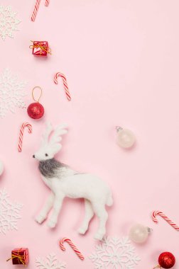 Noel ya da yeni yıl geçmişi. Pastel pembe arka planda beyaz ve kırmızı süslemeler. Noel tatili kavramı. Düz konum, üst görünüm, kopyalama alanı. Tebrik kartı şablonu.