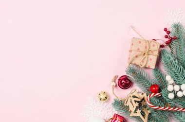 Noel ya da yeni yıl geçmişi. Pastel pembe arka planda beyaz ve kırmızı süslemeler. Noel tatili kavramı. Düz konum, üst görünüm, kopyalama alanı. Tebrik kartı şablonu.