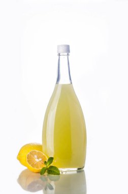Geleneksel İtalyan likörü Limoncello likörü, şarap bardağı ve beyaz üzerine taze limon.