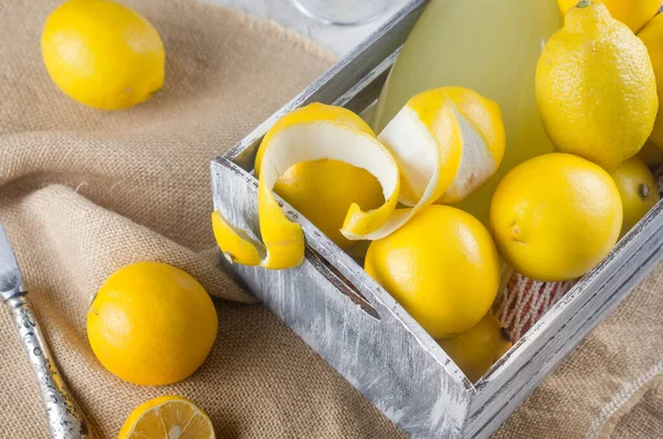 Limoncello Glasflasche Und Frische Reife Gelbe Zitronen Auf Grauem Hintergrund — Stockfoto