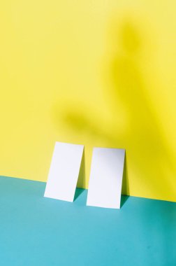 Mavi ve sarı kağıtta gölgeleri olan iki kartvizitin evrensel boş şablonu. Dizaynınızı yerleştirin.