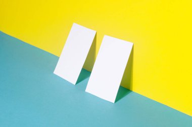 Mavi ve sarı kağıtta gölgeleri olan iki kartvizitin evrensel boş şablonu. Dizaynınızı yerleştirin.