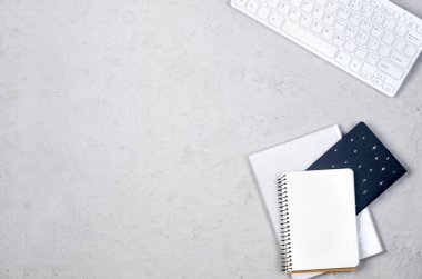 Düz uzanmış, ofis masası manzaralı. Klavyeli gri çalışma masası, boş boş, malzemeler, bardaklar ve kahve kupaları. Asgari tarz ev ofisi ya da Modern Serbest İşyeri.