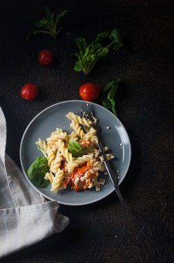 İtalyan makarnası ile Feta peyniri karışımı fırınlanmış ve domatesler koyu arkaplanda. Fetapasta. Viral yemek tarifi, düz konum, kopyalama alanı