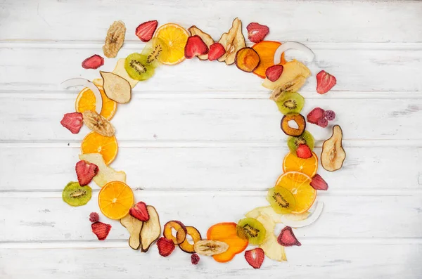 assortied dried chips and ripe fruits on grey background. Fruit chips. Healthy eating concept, snack, no sugar. Top view, copy space.