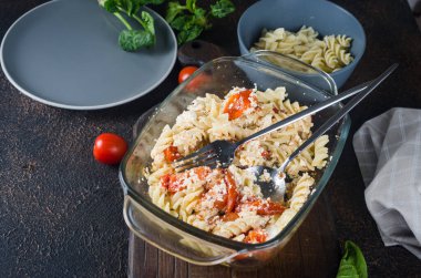 İtalyan makarnası ile Feta peyniri karışımı fırınlanmış ve domatesler koyu arkaplanda. Fetapasta. Viral yemek tarifi, düz konum, kopyalama alanı