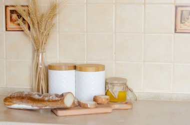 Dilimlenmiş Fransız Ekmeği. Kahvaltı için malzemeler, taze baget ve arka plandaki mutfak aletlerinde domates, İskandinav tarzı. Seçici odak