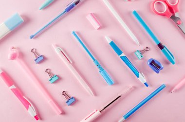 Okul konseptine geri dönelim. Pembe arka planda okul kırtasiyesi olan kalem kutusu. Boş defter kağıdı, kalem, ataç ve kopya alanı olan yapışkan not, düz konum