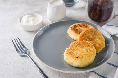 Krema, reçel ve bir fincan latte ile siyah tabakta süzme peynirli krep. Sağlıklı Kahvaltı. Ev yapımı yemek.