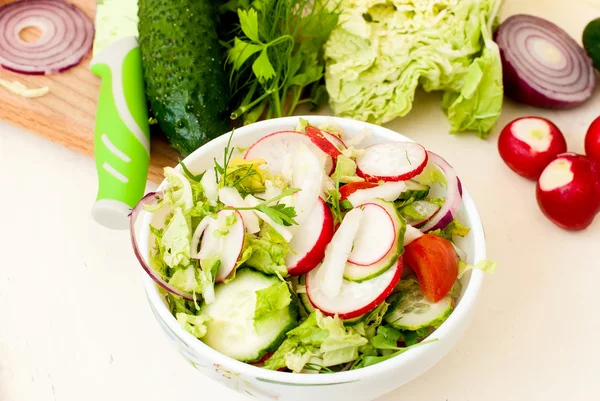 Весенний салат с редиской, огурцом, капустой и луком крупным планом — стоковое фото