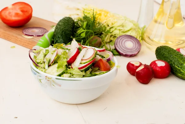 Spring salad with radishes, cucumber, cabbage and onion close-up — Stock Photo, Image