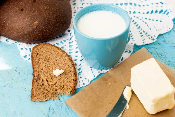 Черный хлеб с маслом и чашка молока — стоковое фото