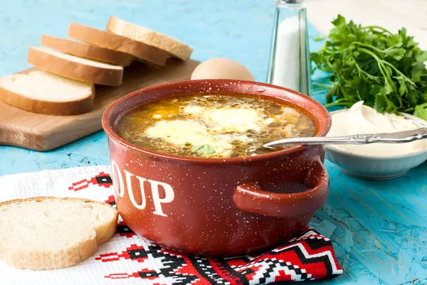 Зеленый суп с яйцом в тарелке — стоковое фото