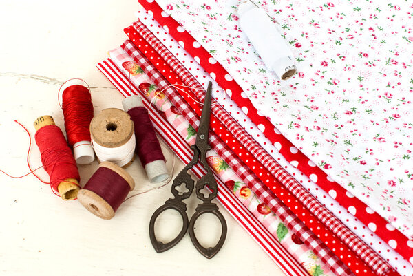 colored fabric spools of thread and scissors for sewing