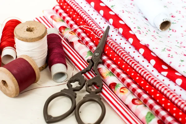 Colored fabric spools of thread and scissors for sewing — Stock Photo, Image