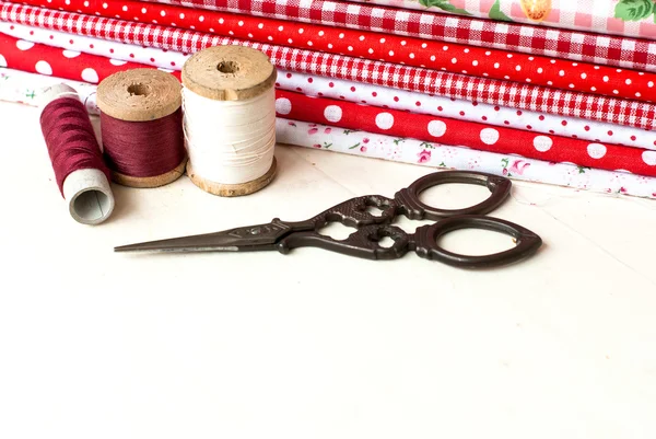 Kolorowe tkaniny szpule nici i nożyczki do szycia — Zdjęcie stockowe