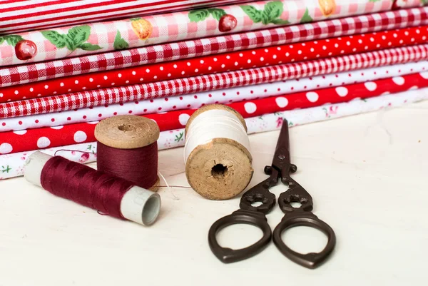 Colored fabric spools of thread and scissors for sewing — Stock Photo, Image