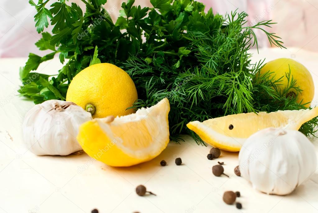 slices of lemon, garlic cloves and parsley on the white backgrou