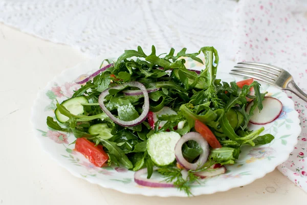 Salatmischung aus Rukolly, Tomaten, Gurken mit roten Ringen auf — Stockfoto