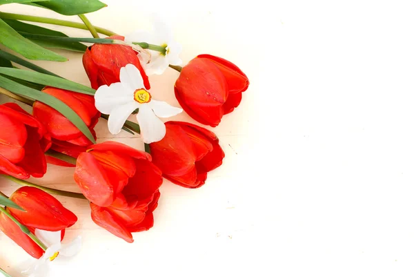 bouquet of daffodils and tulips on a wooden white background