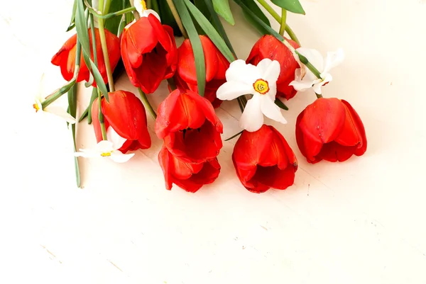 bouquet of daffodils and tulips on a wooden white background