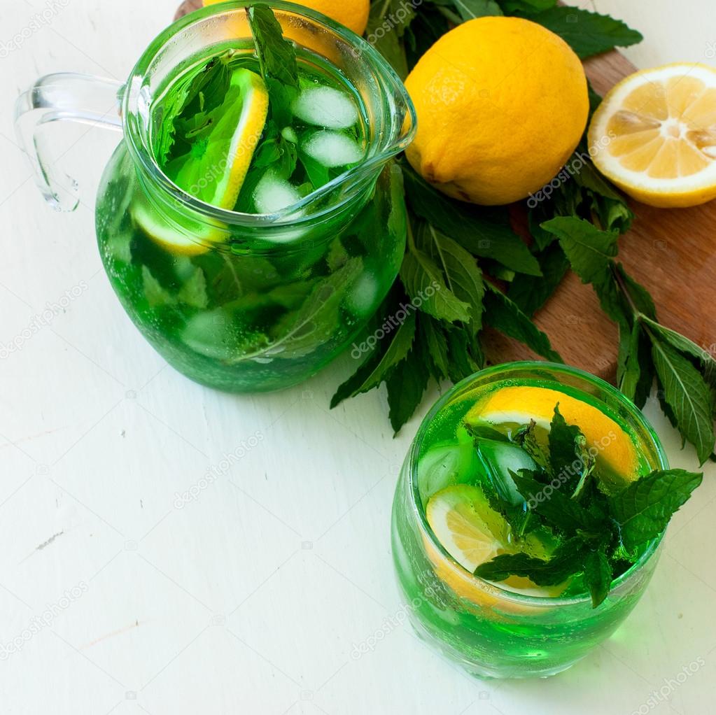 Green mojito cocktail with ice and mint
