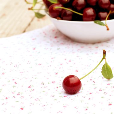single cherry and a plate of cherries