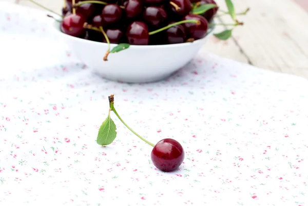 Single cherry and a plate of cherries — Stock Photo, Image