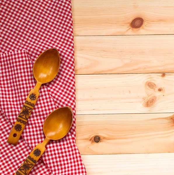 Cucharas de madera sobre una servilleta roja sobre un fondo de madera — Foto de Stock