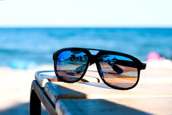 sunglasses lie on a beach on sand