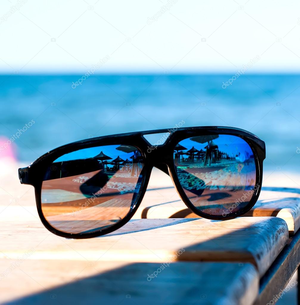 sunglasses lie on a beach on sand