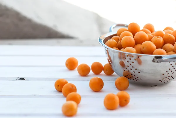 Gula plommon i ett durkslag på en whiteboard — Stockfoto