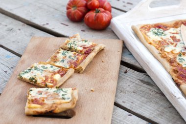 ince pizza domates, rendelenmiş peynir ve otlar ile