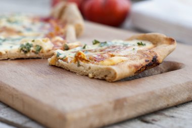 ince pizza domates, rendelenmiş peynir ve otlar ile