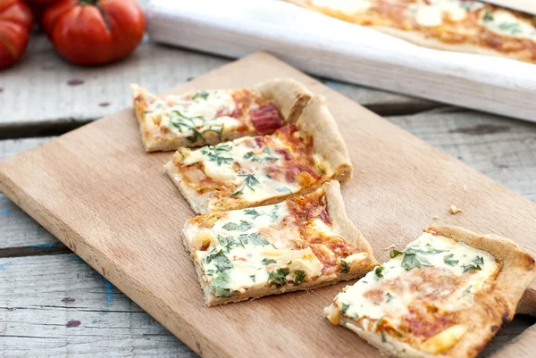Тонкая пицца с помидорами, тертым сыром и травами — стоковое фото