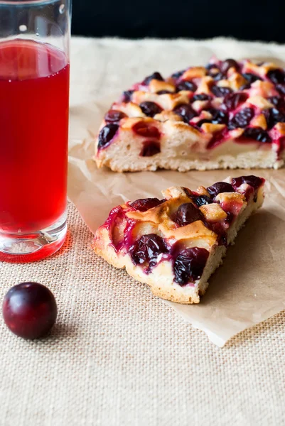 Cake with plums and a glass compote for breakfast — Stockfoto