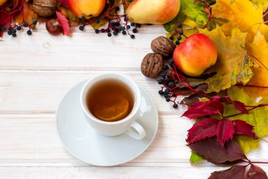 bir fincan çay, elma, armut, fındık ve sonbahar yaprakları. sonbahar hala