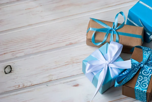Caixas com presentes decorados com fitas em um backgr de madeira branco — Fotografia de Stock