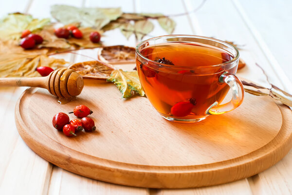 Rosehip drink with fresh berries in a glass cup