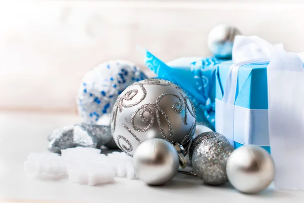 銀のクリスマス ボール、木製のテーブルにプレゼント — ストック写真