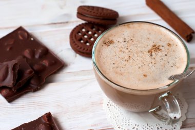 fincan kapuçino ve çikolatalı kurabiye üzerinde bir karanlık adam