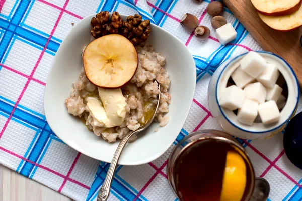 Farina d'avena con burro, bacche e noci a colazione con tè — Foto Stock