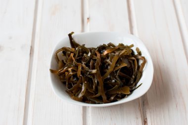 ahşap bir masa üzerinde bir kasede deniz yosunu