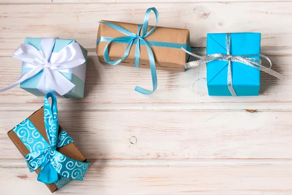 Cajas con regalos decorados con cintas en un fondo de madera blanca —  Fotos de Stock