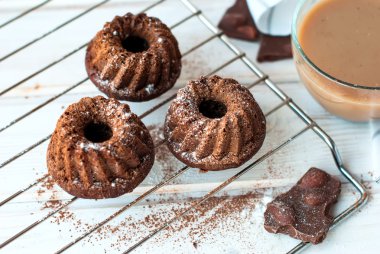 Çikolatalı kek kakao ve bir fincan kahve ile serpilir