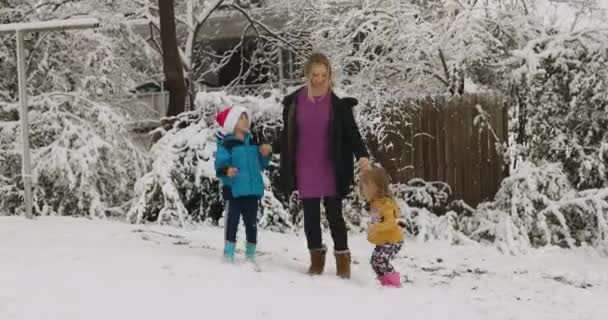 Молодая женщина веселится и танцует с детьми в снежном парке 4k Лицензионные Стоковые Видео