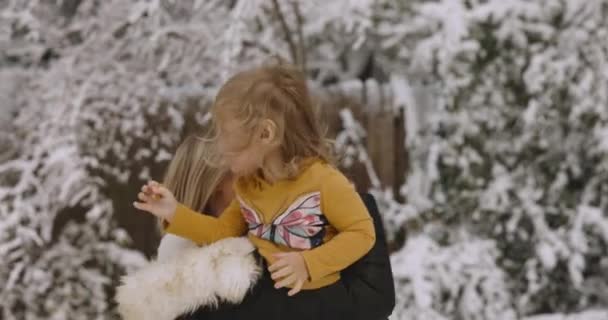 Młoda kobieta bawi się ze swoją córeczką w snowparku w Santa cap 4k Wideo Stockowe